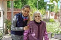 Young attractive woman embracing old grandmother outdoor. Female - generations - love