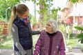 Young attractive woman embracing old grandmother outdoor. Female - generations - love