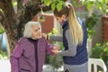 Young attractive woman embracing old grandmother outdoor. Female - generations - love