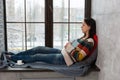 Young attractive woman fall asleep on the windowsill while reading a book Royalty Free Stock Photo