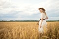 Young attractive woman and golden wheat field. Royalty Free Stock Photo