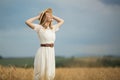 Young attractive woman and golden wheat field. Royalty Free Stock Photo