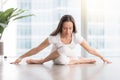 Young attractive woman in Gomukasana pose against floor window Royalty Free Stock Photo