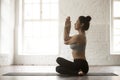 Young attractive woman in Gomukasana pose, white loft studio bac Royalty Free Stock Photo