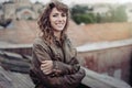 Young attractive woman with good mood enjoying beautiful city landscape while standing on a roof of building, charming smiling hip Royalty Free Stock Photo