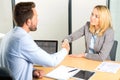 Young attractive woman handshaking at the end of a job interview