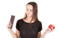 Young attractive woman holding red apple fruit and chocolate bar in hands Royalty Free Stock Photo