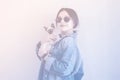 Young attractive woman hugging pussy cat in hands. Cute and glamorous girl in trendy sunglasses posing with her Siamese cat Royalty Free Stock Photo