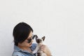 Young attractive woman hugging pussy cat in hands. Cute and glamorous girl in trendy sunglasses posing with her Siamese cat Royalty Free Stock Photo