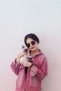 Young attractive woman hugging pussy cat in hands. Cute and glamorous girl in trendy sunglasses posing with her Siamese cat Royalty Free Stock Photo