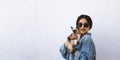 Young attractive woman hugging pussy cat in hands. Cute and glamorous girl in trendy sunglasses posing with her Siamese cat Royalty Free Stock Photo