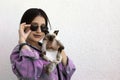 Young attractive woman hugging pussy cat in hands. Cute and glamorous girl in trendy sunglasses posing with her Siamese cat Royalty Free Stock Photo