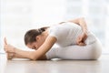 Young attractive woman in Janu Sirsasana pose against floor wind Royalty Free Stock Photo