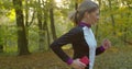 Young attractive woman listening music in the earphone while running in the city park. Royalty Free Stock Photo