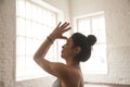 Young attractive woman making Namaste, white loft studio, side v Royalty Free Stock Photo