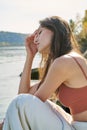 A young attractive woman of model appearance rests under a blanket on a pier. long hair