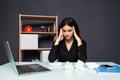 Young attractive woman at modern office desk, working on laptop, massaging temples to forget about constant headaches, noisy loud Royalty Free Stock Photo