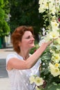 Young attractive woman near the flowers in the garden. Under the Royalty Free Stock Photo