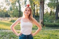 Young attractive woman outdoor holding red apple on her head and thinking about something on the blur nature background Royalty Free Stock Photo