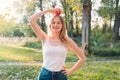 Young attractive woman outdoor holding red apple on her head and thinking about something on the blur nature background Royalty Free Stock Photo