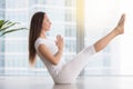 Young attractive woman in Paripurna Navasana pose against floor Royalty Free Stock Photo