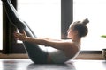 Young attractive woman in Paripurna Navasana pose, home interior