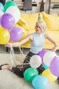 young attractive woman in party hat siting on floor with colorful