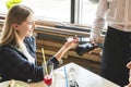 Young attractive woman paying in cafe with contactless smartphone payment Royalty Free Stock Photo