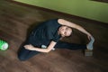 Young attractive woman performs Parivritta Janu Shirshasana exercise, tilting head to knees