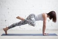 Young attractive woman in Plank pose, variation, white studio