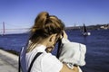 A young and attractive woman posing and relaxing alone along the Tagus river bank, Lisbon. Beautiful girl wearing a jeans jacket Royalty Free Stock Photo