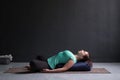 Woman practicing yoga concept, lying in Reclined Butterfly exercise Royalty Free Stock Photo