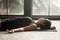 Young attractive woman in Savasana pose, studio background Royalty Free Stock Photo