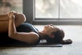 Young attractive woman in Apanasana pose, studio background Royalty Free Stock Photo