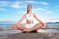 Young attractive woman practicing yoga at lake shore. Royalty Free Stock Photo
