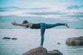 Young attractive woman practicing yoga, standing in Warrior three exercise, Virabhadrasana III pose Royalty Free Stock Photo