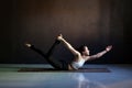 Young attractive woman practicing yoga, stretching in Salabhasana pose