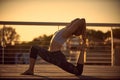 Young woman practicing yoga asana King Pigeon pose rajakapotasana in the terrace at sunset