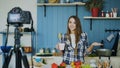 Young attractive woman recording video food blog about cooking on dslr camera in kitchen Royalty Free Stock Photo