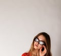 Young attractive woman in red on gray background with copy space. Woman posing with sunglasses. Scar on face Royalty Free Stock Photo