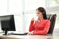 Young attractive woman in red jacket sitting on desk at head of executive in red jacket. Holds video conference in Royalty Free Stock Photo