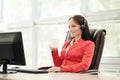 Young attractive woman in red jacket sitting on desk at head of executive in red jacket. Holds video conference in Royalty Free Stock Photo