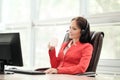 Young attractive woman in red jacket sitting on desk at head of executive in red jacket. Holds video conference in Royalty Free Stock Photo