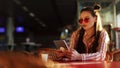 Young attractive woman in red sunglasses with tablet computer sitting in cafe. Beautiful girl in airport or shoppping