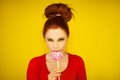 Young attractive woman in red and yellow with perfect make up holding a swirl lollipop Royalty Free Stock Photo