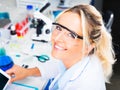 Young attractive woman scientist writing research report in the