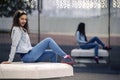 Young and attractive woman is sitting on the bench in industrial park. Royalty Free Stock Photo