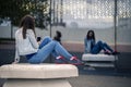 Young and attractive woman is sitting on the bench in industrial park. Royalty Free Stock Photo