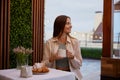 Young attractive woman sitting at table drinking coffee in cafe Royalty Free Stock Photo