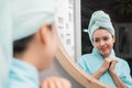 Young attractive woman standing in front of mirror with towel Royalty Free Stock Photo